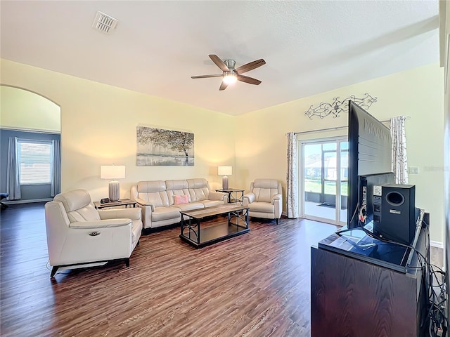 living room featuring ceiling fan and dark wood-type flooring