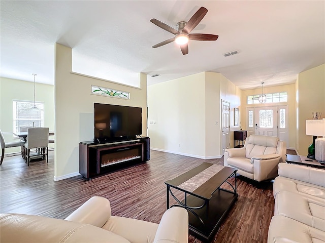 living room featuring ceiling fan and dark wood-type flooring