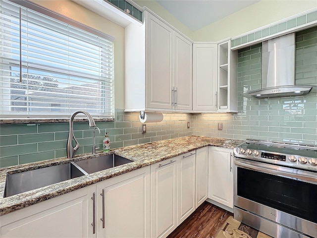 kitchen featuring tasteful backsplash, light stone counters, sink, stainless steel stove, and white cabinetry