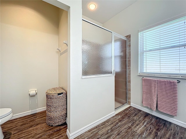 bathroom with hardwood / wood-style flooring, toilet, and walk in shower