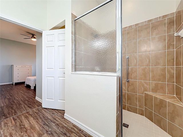 bathroom featuring ceiling fan, wood-type flooring, and walk in shower