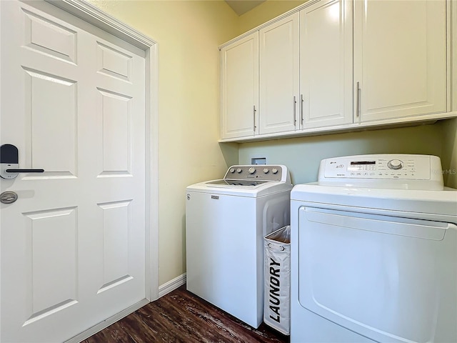 laundry area with cabinets, dark hardwood / wood-style floors, and washing machine and dryer