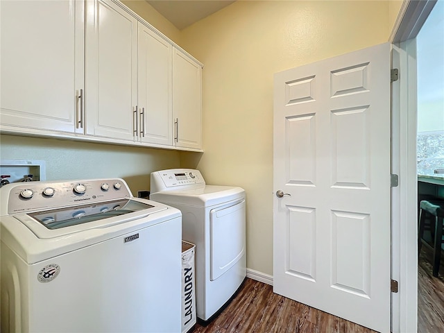 laundry room featuring cabinets, dark hardwood / wood-style floors, and independent washer and dryer