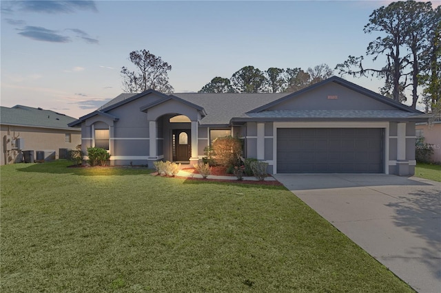 ranch-style house featuring a garage and a yard