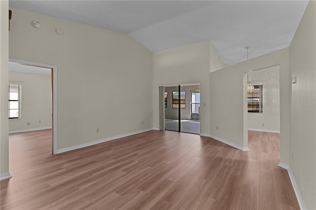 unfurnished room featuring high vaulted ceiling and light hardwood / wood-style flooring