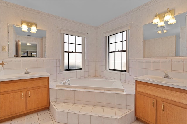 bathroom featuring vanity, tiled tub, and a healthy amount of sunlight