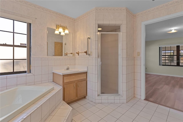 bathroom with tile patterned floors, shower with separate bathtub, a textured ceiling, tile walls, and vanity