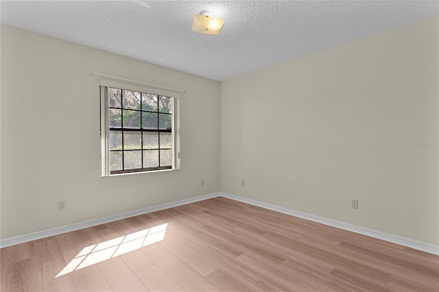 empty room featuring light hardwood / wood-style flooring and a textured ceiling