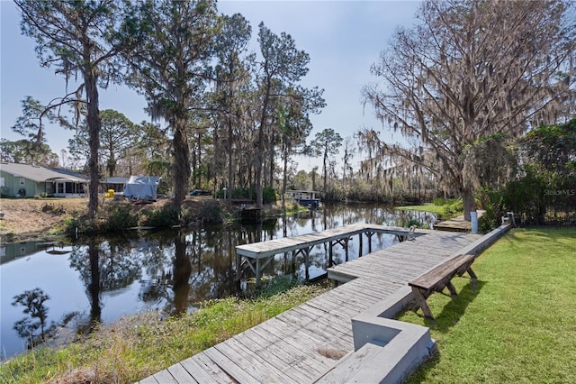 view of dock with a water view and a yard