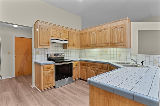 kitchen featuring stainless steel electric range oven, tile countertops, sink, kitchen peninsula, and light hardwood / wood-style flooring