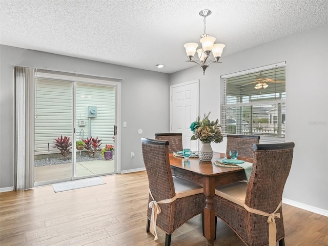 dining room featuring a textured ceiling, light hardwood / wood-style flooring, and a chandelier