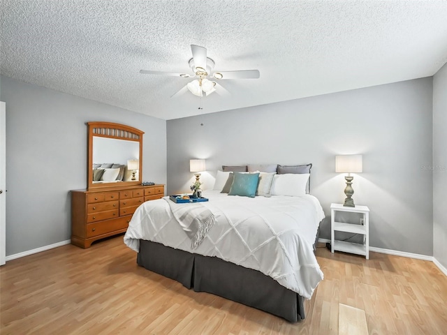 bedroom featuring light wood-type flooring, ceiling fan, and a textured ceiling