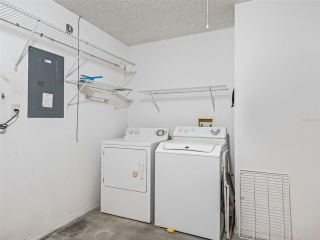 laundry area featuring a textured ceiling, electric panel, and independent washer and dryer