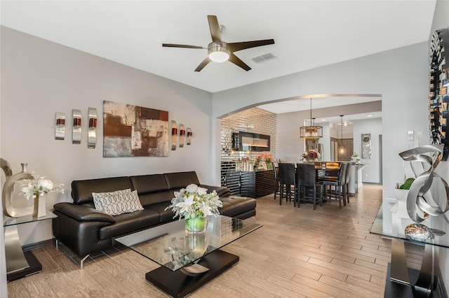 living room with ceiling fan with notable chandelier