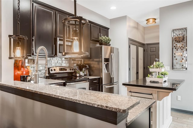 kitchen featuring appliances with stainless steel finishes, dark brown cabinetry, light hardwood / wood-style floors, and light stone counters