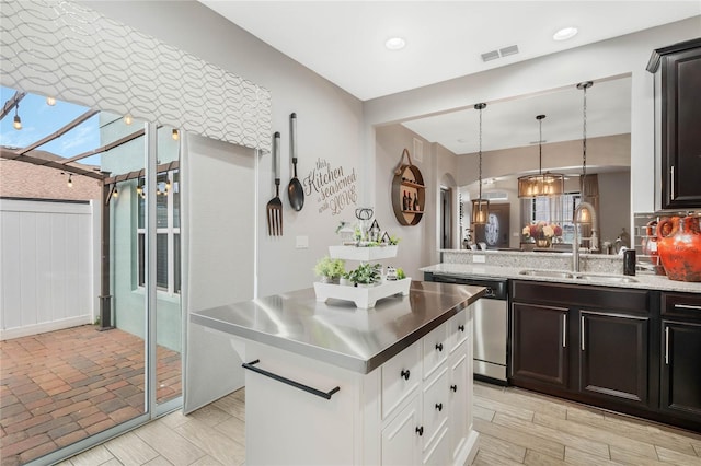 kitchen featuring a notable chandelier, white cabinets, sink, stainless steel dishwasher, and decorative light fixtures