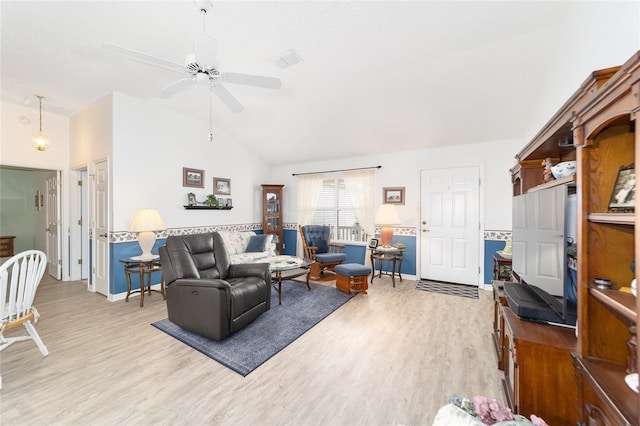 living room with ceiling fan, light wood-type flooring, and vaulted ceiling