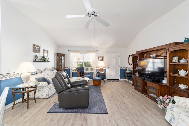 living room featuring ceiling fan, lofted ceiling, and light hardwood / wood-style flooring