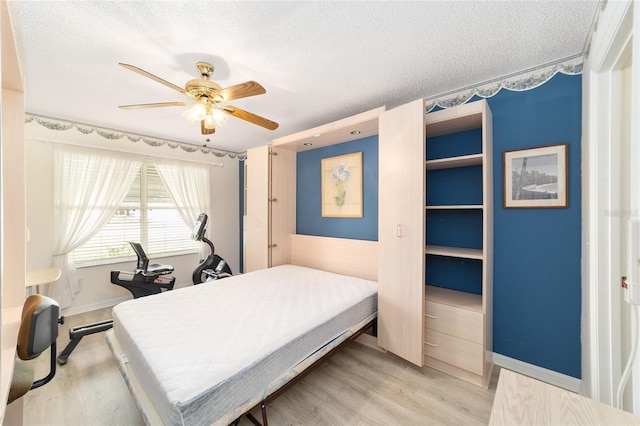 bedroom featuring ceiling fan, light hardwood / wood-style floors, and a textured ceiling