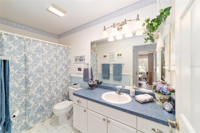 bathroom with vanity, a textured ceiling, and toilet