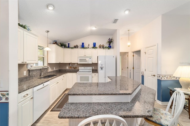 kitchen featuring pendant lighting, white appliances, a center island, and sink