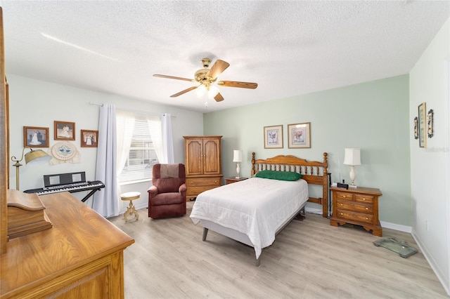 bedroom featuring ceiling fan, light hardwood / wood-style floors, and a textured ceiling