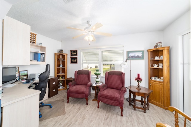 office area with ceiling fan, light hardwood / wood-style flooring, and a textured ceiling