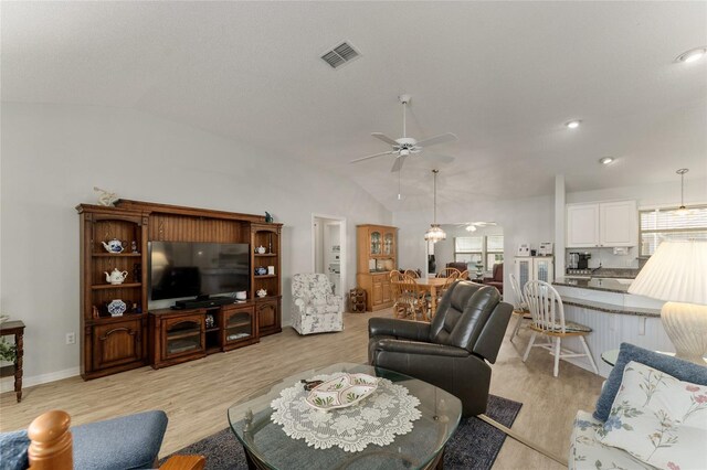 1904 De Hoyos Pl, The Villages, FL 32159 - living area featuring baseboards, light wood-style flooring, visible vents, lofted ceiling, and ceiling fan
