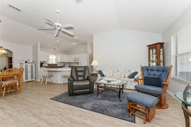 1904 De Hoyos Pl, The Villages, FL 32159 - living room with visible vents, ceiling fan with notable chandelier, vaulted ceiling, and a textured ceiling
