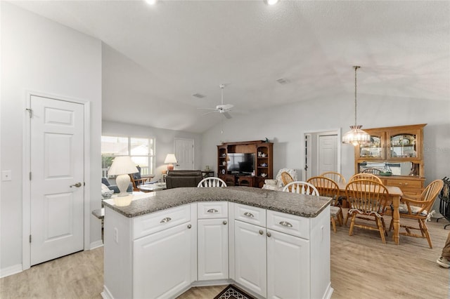 1904 De Hoyos Pl, The Villages, FL 32159 - kitchen with light wood-style floors, white cabinetry, a ceiling fan, and vaulted ceiling