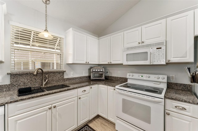 1904 De Hoyos Pl, The Villages, FL 32159 - kitchen with hanging light fixtures, white cabinets, a sink, white appliances, and vaulted ceiling