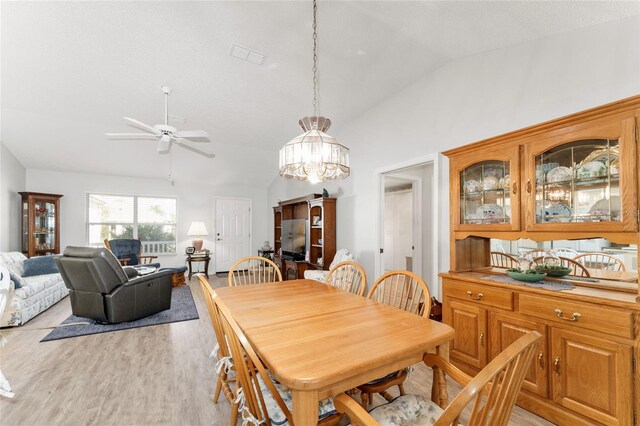 1904 De Hoyos Pl, The Villages, FL 32159 - dining room featuring ceiling fan with notable chandelier, light wood-style floors, and lofted ceiling