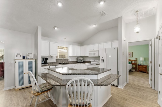 1904 De Hoyos Pl, The Villages, FL 32159 - kitchen with visible vents, a center island, white cabinets, a sink, and white appliances
