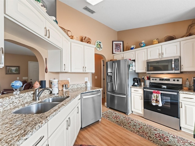 kitchen with appliances with stainless steel finishes, white cabinetry, and sink