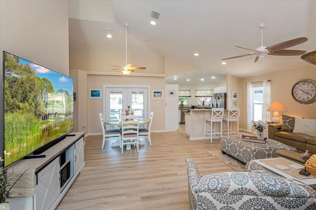 living room with french doors, ceiling fan, high vaulted ceiling, and light hardwood / wood-style floors