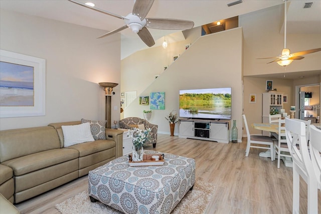 living room featuring ceiling fan, lofted ceiling, and light hardwood / wood-style floors