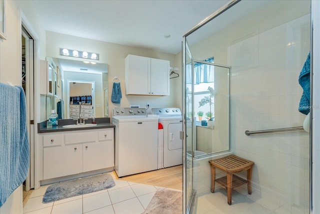 bathroom with tile patterned flooring, vanity, washer and dryer, and a shower with shower door