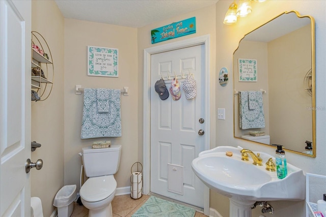 bathroom featuring sink, toilet, and tile patterned flooring