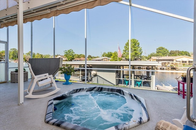 view of patio / terrace with a jacuzzi and a water view