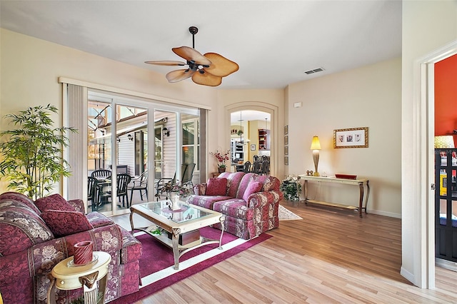 living room with ceiling fan and light hardwood / wood-style flooring