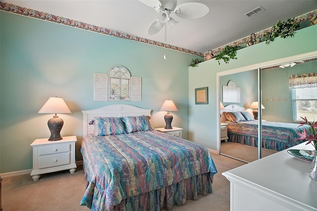 bedroom with ceiling fan, a closet, and light carpet