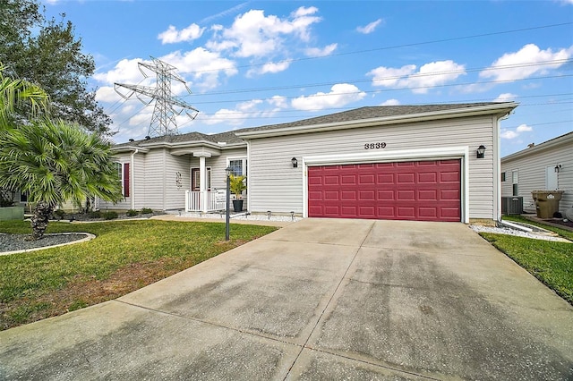 ranch-style home featuring a garage, a front yard, and central AC