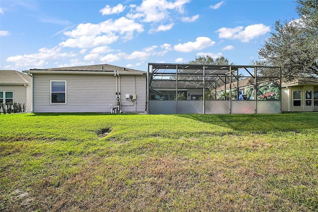 back of property with a yard and glass enclosure