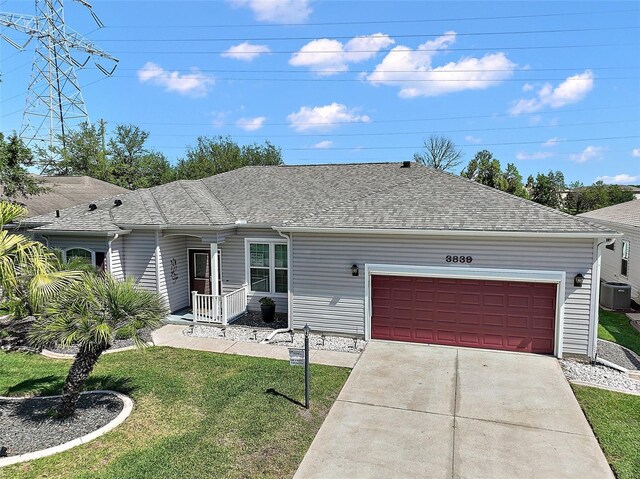 3839 Manor Oaks Ct, Leesburg, FL 34748 - ranch-style home with concrete driveway, roof with shingles, an attached garage, a front yard, and central AC