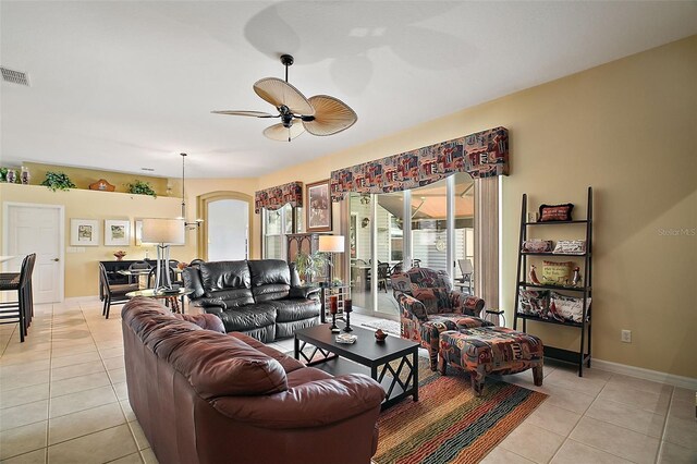 3839 Manor Oaks Ct, Leesburg, FL 34748 - living room with visible vents, baseboards, a ceiling fan, and light tile patterned flooring