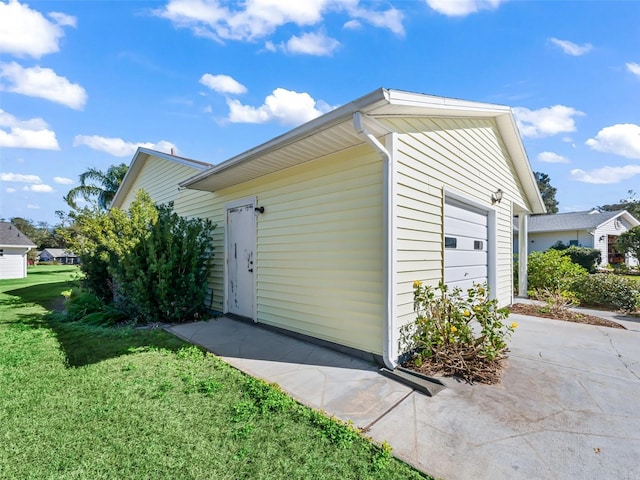 view of side of property featuring a yard and a garage