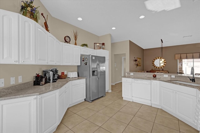 kitchen with pendant lighting, white dishwasher, sink, stainless steel fridge, and white cabinetry