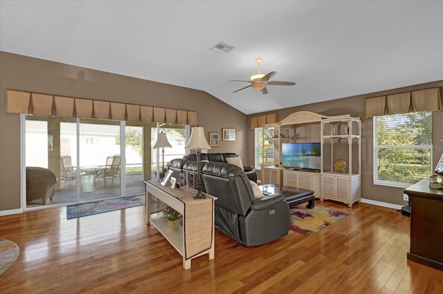 living room with hardwood / wood-style flooring, ceiling fan, and vaulted ceiling