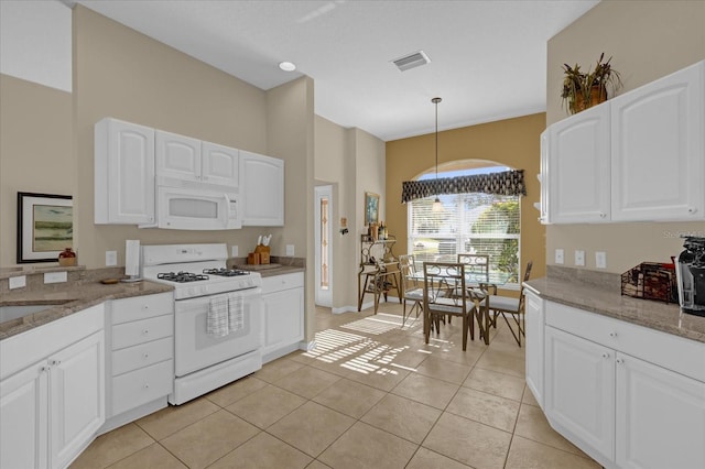 kitchen with white cabinetry, hanging light fixtures, stone countertops, white appliances, and light tile patterned flooring