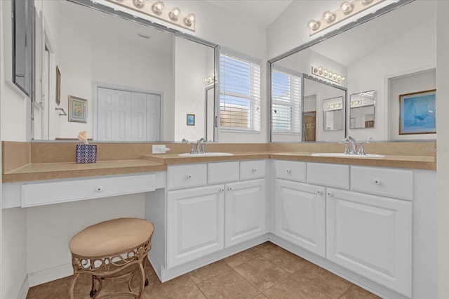 bathroom featuring tile patterned flooring, vanity, and vaulted ceiling